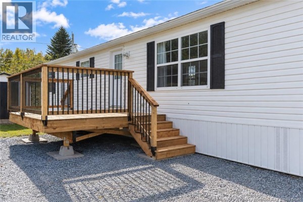 Close-up of the wooden deck with black railings and stairs leading up to the mobile home. - 13 Wood Avenue, Lincoln