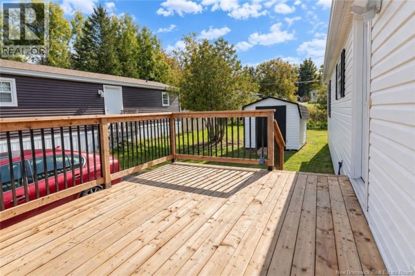 View from the wooden deck showing the side of the house and the backyard with a shed. - 13 Wood Avenue, Lincoln