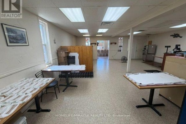 Counter area with cash register, menu board, and freezers. - 13 Yonge Street S, Springwater