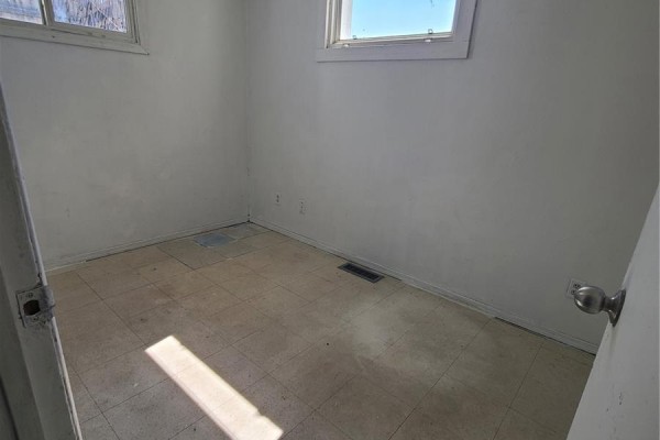 Small room with white walls, tiled floor, and two windows, viewed from the doorway. - 130 26th Street W, Prince Albert