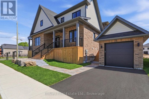 Side view of a brick house with a covered porch and attached garage. - 130 Fifth Street, Collingwood