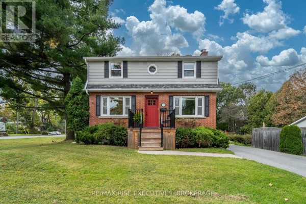 Exterior view of the brick house with a red front door and manicured lawn. - 130 Florence Street, Kingston