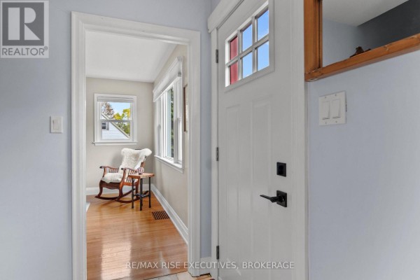 Interior view of the entrance hall looking into a living room with a rocking chair. - 130 Florence Street, Kingston