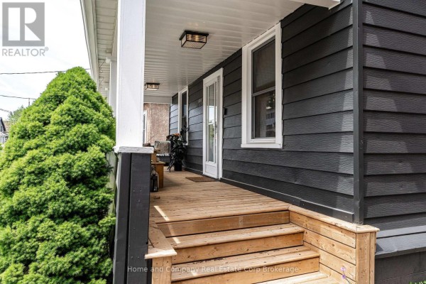 Wooden steps leading up to the front porch of a dark grey siding house. - 130 Rebecca Street, Stratford