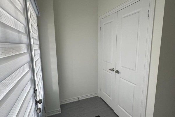 Interior entryway with gray tiled floor, white walls, and white double doors. - 130 Sapphire Way, Thorold