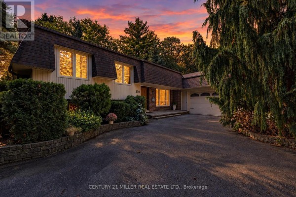 Front view of the house with a circular driveway and greenery - 130 Tavistock Square, Oakville