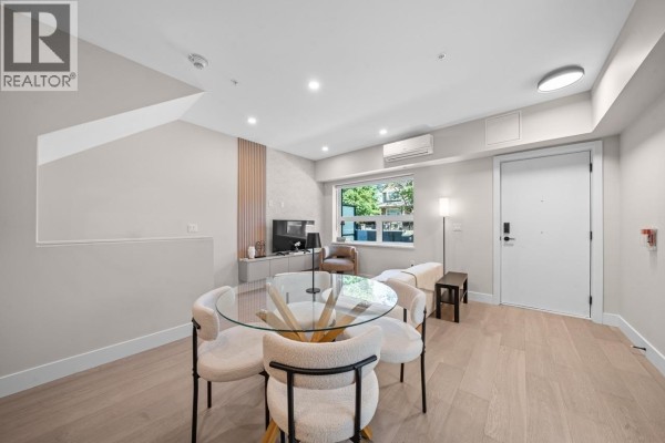 Living and dining area with a glass table, four chairs, sofa, and a door. - 130 W Woodstock Avenue, Vancouver