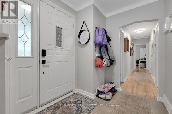 Entranceway with a white front door, coat rack, and shoe storage. - 1300 Field Street, Ottawa