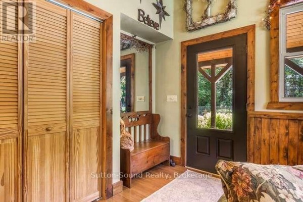Interior entryway with a wooden bench, mirrored wall, and bi-fold closet doors. - 130044 Sideroad 20 Side Road, Georgian Bluffs