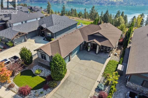 Aerial view of the property, highlighting the house, driveway, and proximity to the lake. - 13011 East Ridge Drive, Lake Country