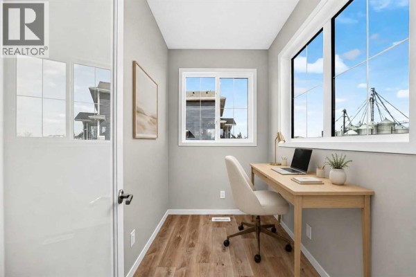 Small office with a desk, chair, laptop, and windows with exterior view. - 1302 Mahogany Boulevard Se, Calgary
