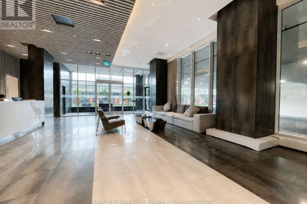 Spacious, modern lobby with high ceilings, polished floors, seating area, and large windows. - 1303 - 2481 Taunton Road, Oakville