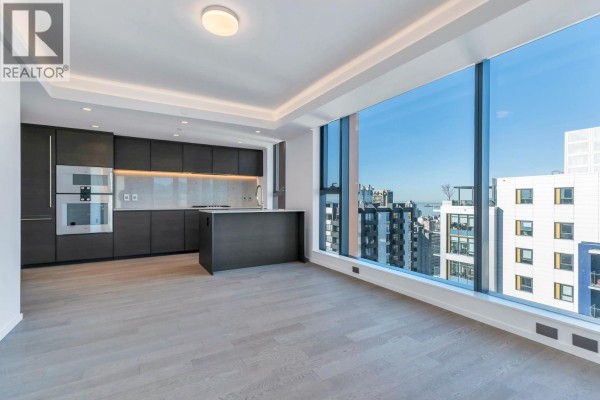 Spacious kitchen layout with island, large windows, and city skyline view - 1303 1408 Robson Street, Vancouver