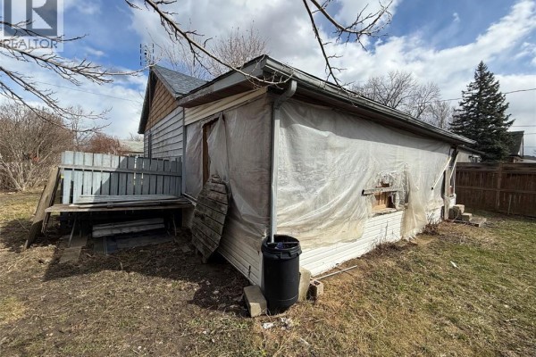 Back exterior with plastic sheeting, deck, and fence - 1303 Central Windsor