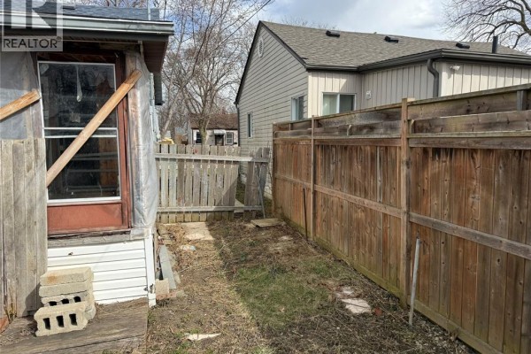 Backyard with wooden fence and old structure - 1303 Central Windsor