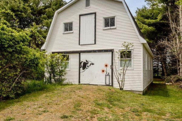 Exterior view of a wooden deck with steps leading to a white door, red chairs visible. - 1303 Highway 201, Round Hill