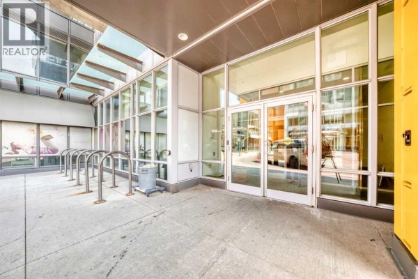 Entrance to apartment buildings with glass doors, windows, and a bike rack outside. - 1304, 3820 Brentwood  Nw, Calgary