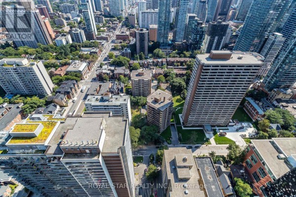 Aerial view looking down at city streets, apartment buildings, and surrounding greenery. - 1304 - 55 Charles Street E, Toronto