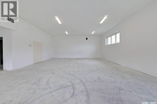 Large open warehouse space with concrete floor and fluorescent lighting on ceiling. - 1304 Hamilton Street, Regina