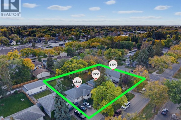 Aerial view of three houses on a street with mature trees and fall foliage. - 1304/1308/1312 Main Street, Saskatoon