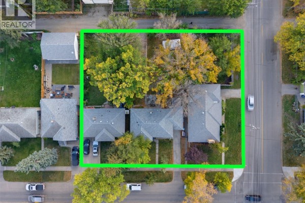 Aerial view of three houses on a street with mature trees and fall foliage. - 1304/1308/1312 Main Street, Saskatoon