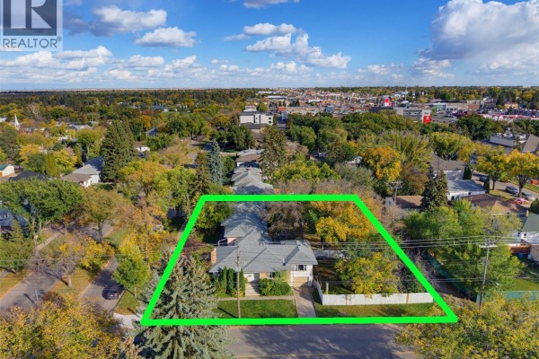 Aerial view of a property with three houses and surrounding neighborhood in fall. - 1304/1308/1312 Main Street, Saskatoon