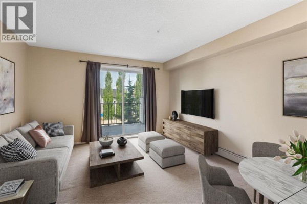 Living room with a grey sofa, wooden coffee table, and a sliding glass door. - 1305, 8 Bridlecrest Drive Sw, Calgary