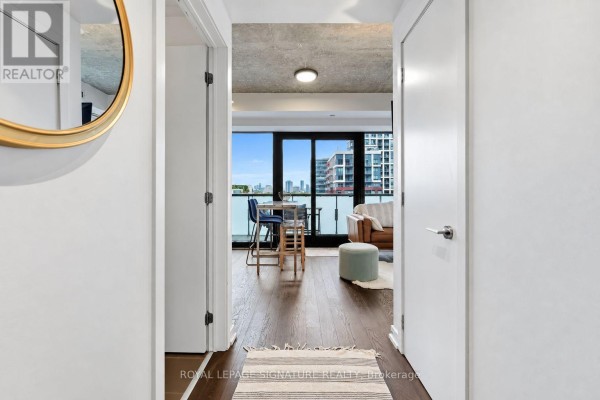 View from hallway into living room with couch, coffee table, and balcony doors. - 1305 - 11 Charlotte Street, Toronto