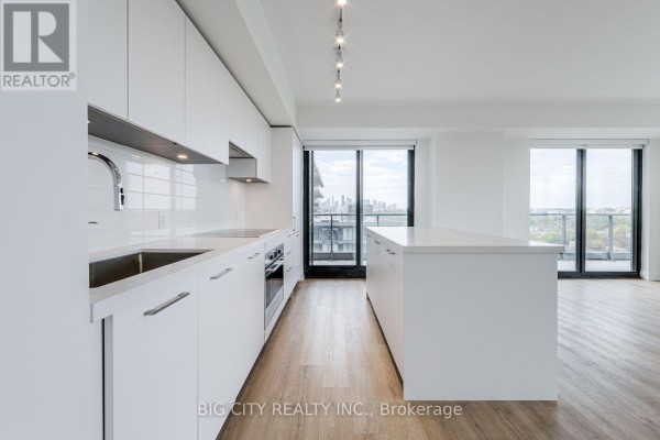 Modern white kitchen with white countertops, subway tile backsplash, stainless steel appliances, and an island. - 1305 - 36 Brentcliffe Road, Toronto