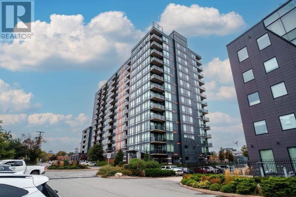 Side view of a tall apartment building with dark exterior panels and glass balconies. - 1305 3471 Dutch Village Road, Halifax