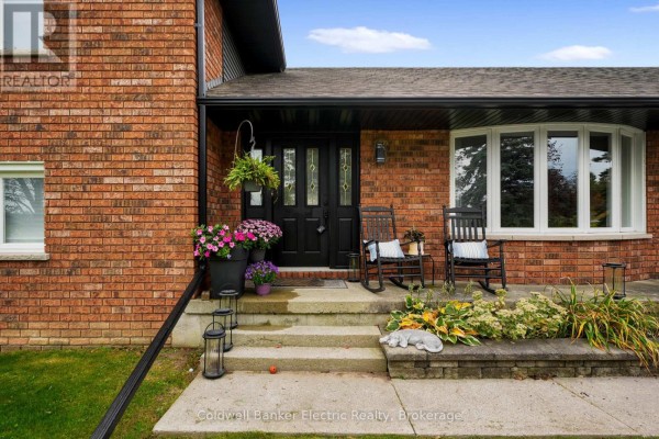 Front entrance with double doors, stone steps, and potted plants on the porch. - 1305 Holden Road, Selwyn