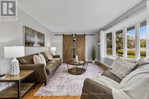 Living room with leather sofas, a round coffee table, and rustic barn doors. - 1305 Holden Road, Selwyn