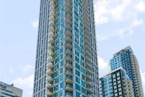 Tall condominium building with many balconies and blue-tinted windows. - 1307, 901 10 Avenue Sw, Calgary
