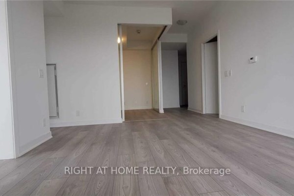 Interior view of an apartment with light wood laminate floors and white walls. - 1308 - 120 Parliament Street, Toronto