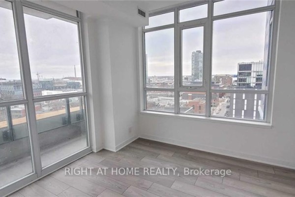 Room with large windows and glass sliding door, overlooking a city view. - 1308 - 120 Parliament Street, Toronto