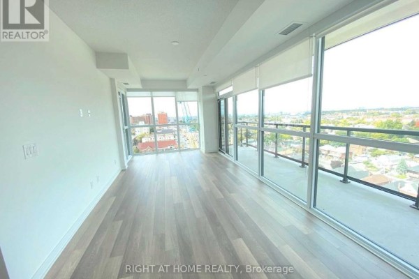 Open concept living area with light wood floors, large windows, and a balcony. - 1308 - 1603 Eglinton Avenue W, Toronto