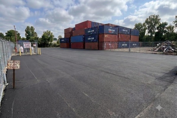 Stacked shipping containers and fencing adjacent to an asphalt lot with a propane flare station. - 13087 116 Avenue, Surrey