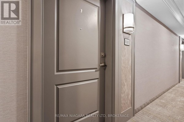 Apartment door 131 with modern light fixtures in a hallway. - 131 - 5055 Greenlane Road, Lincoln