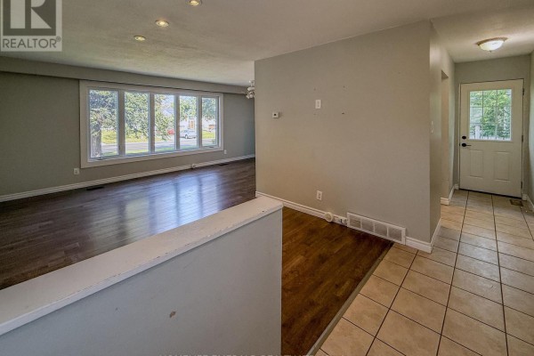 Interior view of a hallway and living room with hardwood floors. - 131 Cundles Road E, Barrie