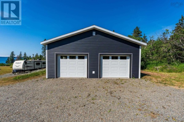 Front view of a dark blue garage with two white doors and an RV. - 131 Doty Branch, Ashmore