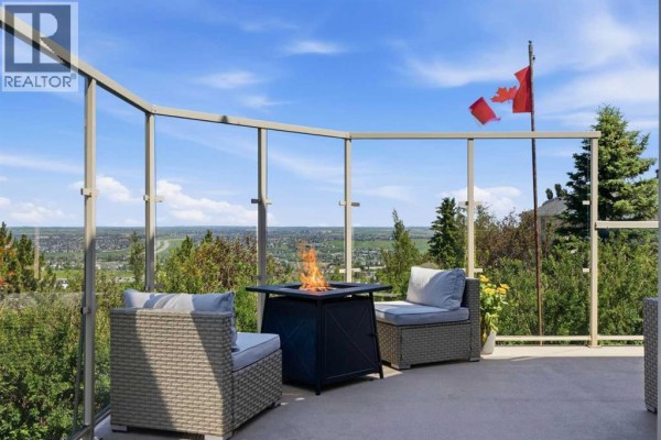 Basement family room with a large TV, sectional sofa, and children's play area. - 131 Edgebrook Circle Nw, Calgary