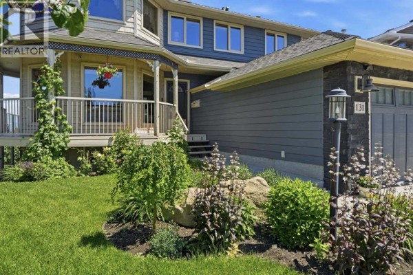 White kitchen with white cabinets, tiled backsplash, and laminate flooring. - 131 Edgebrook Circle Nw, Calgary