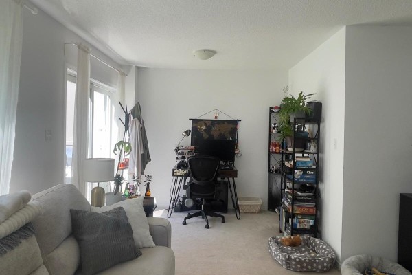 Living room space with a sofa, desk, computer, and shelving unit. - 131 Franks Way, Barrie