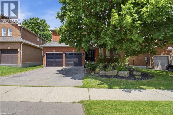 Close-up of the entrance to a brick house with double garage doors and landscaping. - 131 Huntingwood Avenue, Hamilton