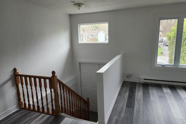 A driveway leads to the front entrance of a two-story brick house with a lawn on the left. - 131 Rue Sicard, Gatineau
