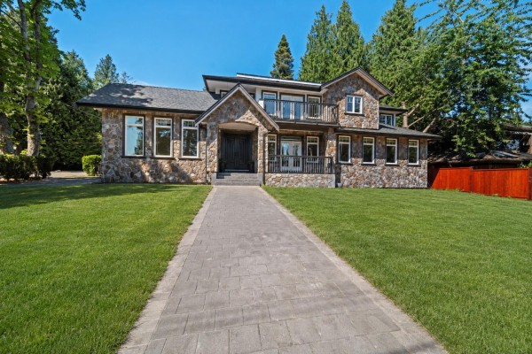 Exterior view of a large stone house with a paved walkway leading to the front entrance. - 13101 14 Avenue, Surrey