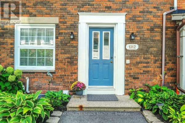 Close-up of the blue front door with address 1312, framed by brick. - 1312 Cornell Street, Ottawa