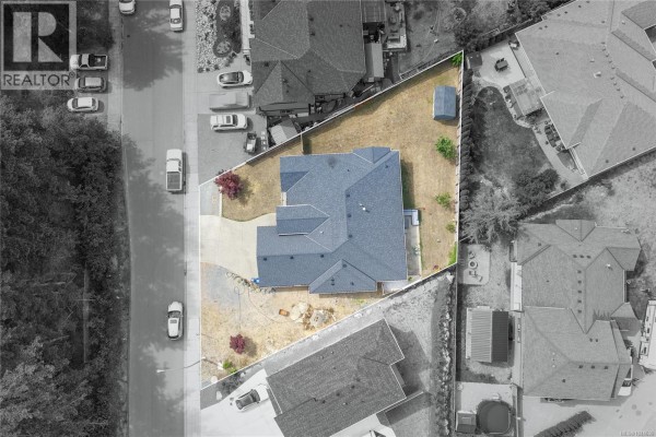 Overhead view of a modern house with a gray roof and surrounding asphalt road. - 1312 Langara Dr, Nanaimo