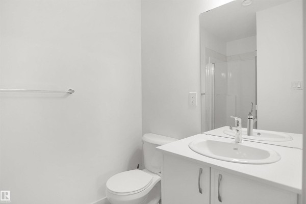 Modern bathroom featuring white fixtures and mirror lighting - 13131 214 St Nw, Edmonton