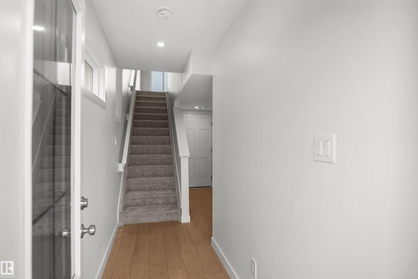 Office space featuring mirrored closet doors and a view of the staircase - 13133 214 St Nw, Edmonton